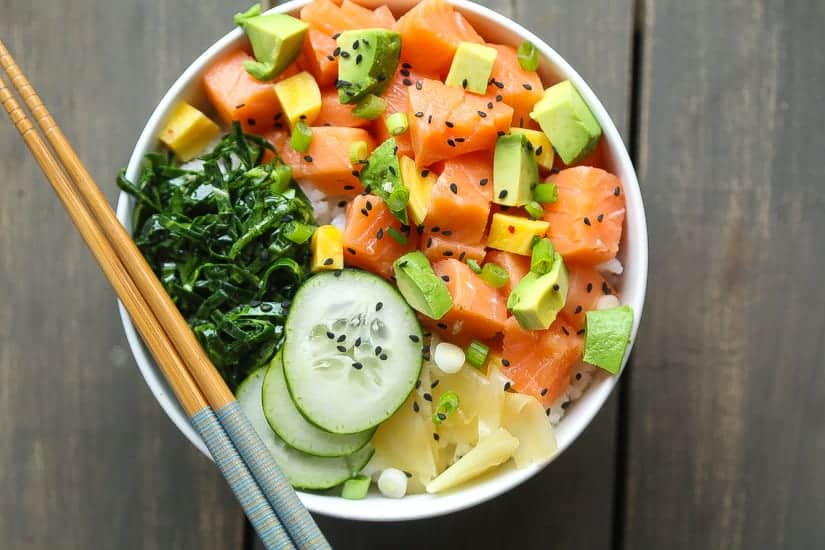 salmon poke bowl with cucumbrs, collard green salad, avocado, pickled beets and ginger
