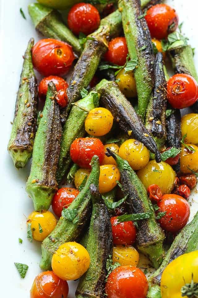 skillet blistered okra and tomatoes on a white platter