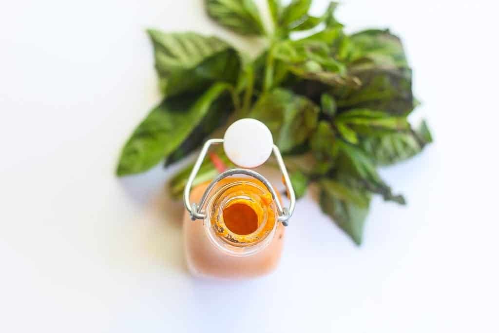 overhead shot of bottled roasted red pepper sauce with basil