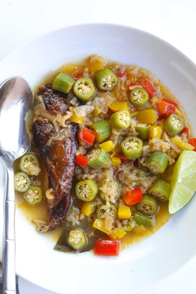 smoked chicken and okra soup in a white bowl with silver spoon