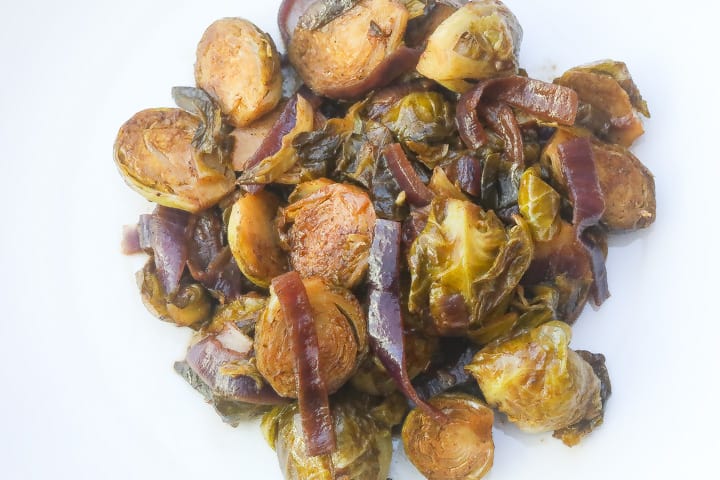 braised brussel sprouts with onions on white plate