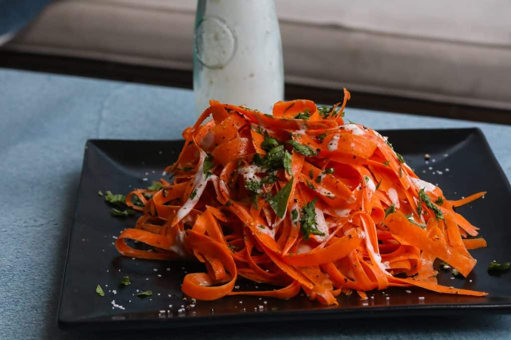 shedded carrot salad on black plate