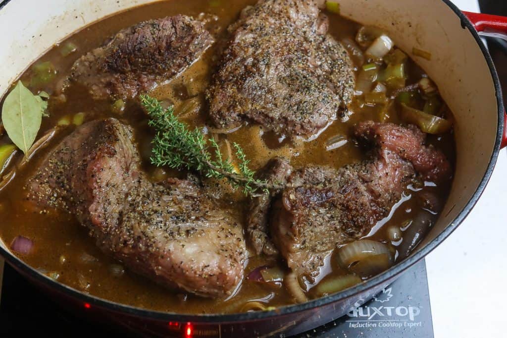 brisket chunks cooking in a pan