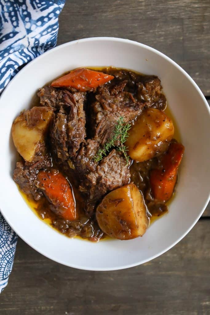 beef pot roast in a bowl with carrots and potatoes