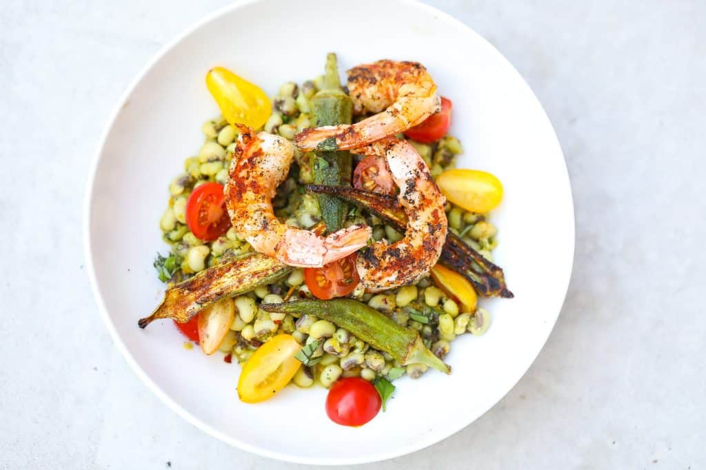 field peas, okra, and tomatoes in a white bowl