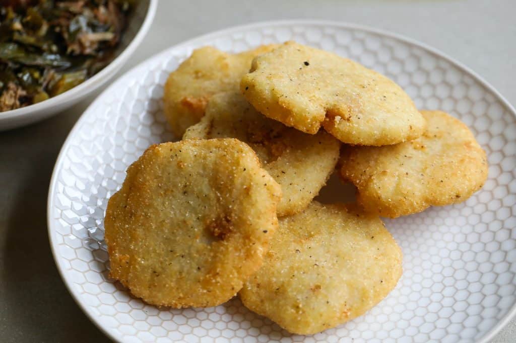 hot water cornbread patties stacked on white plate