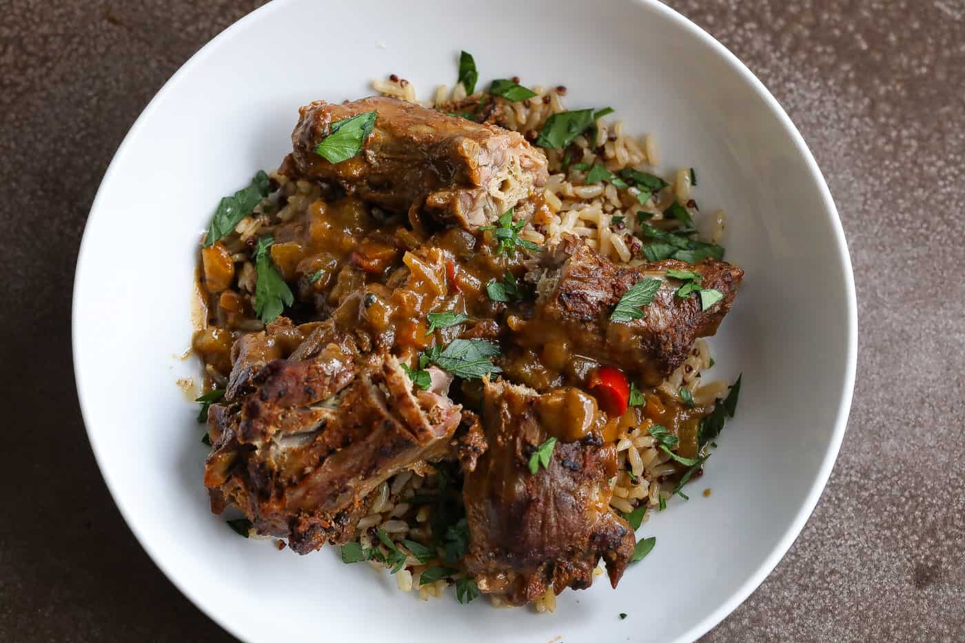 smothered turkey necks on top of a bowl of rice