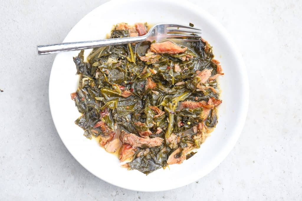 collard greens and turkey in white bowl