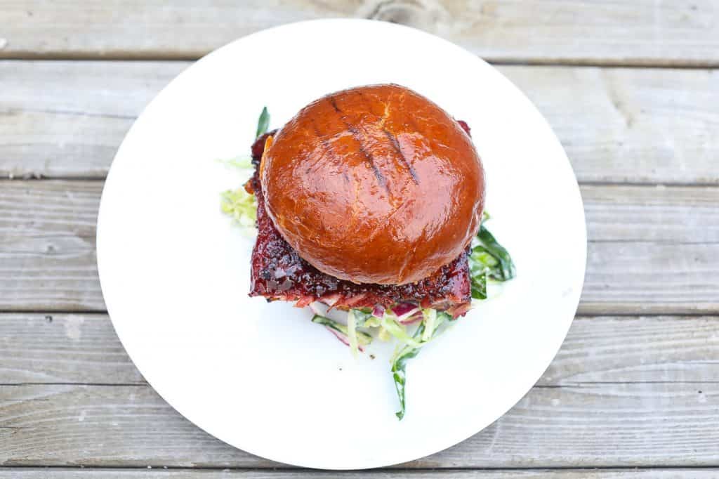 smoked rib sandwich on white plate