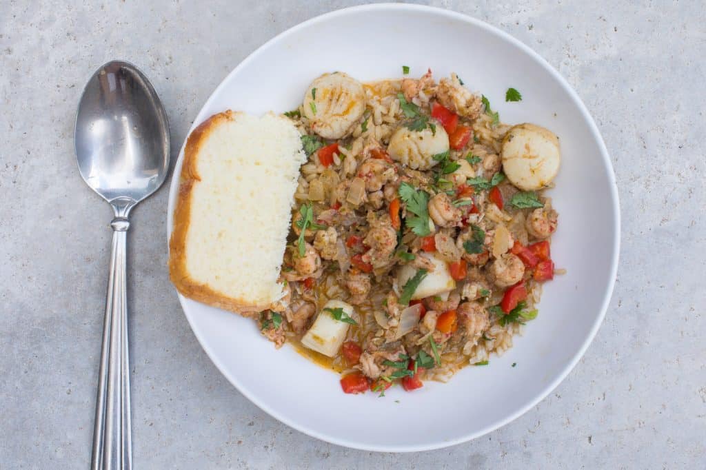 seafood stew in white bowl with rice