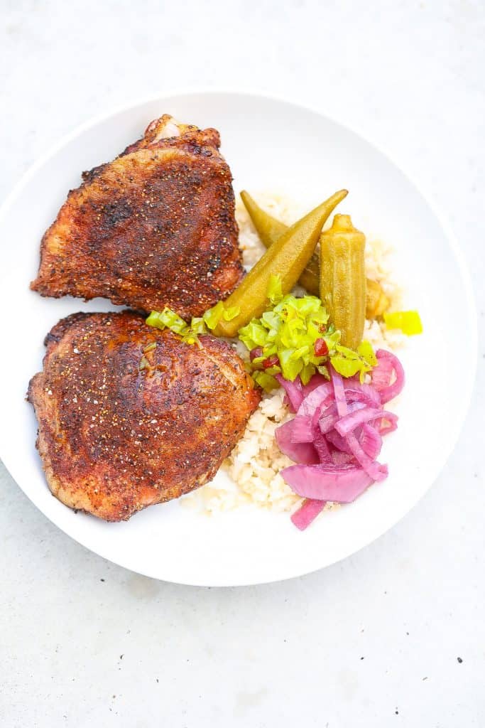 smoked chicken thighs in a white bowl with onions and okra