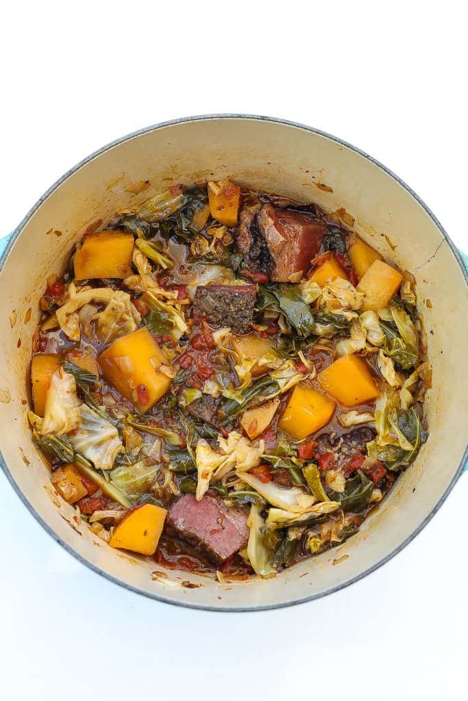 cabbage stew with brisket and rutabagas in blue pot.