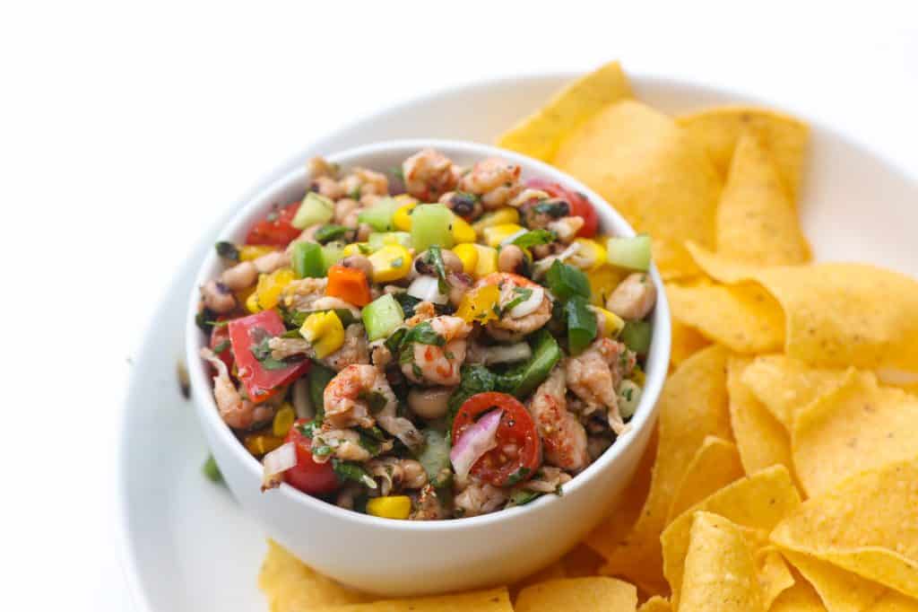 tortilla chips and black eyed salad in a white bowl