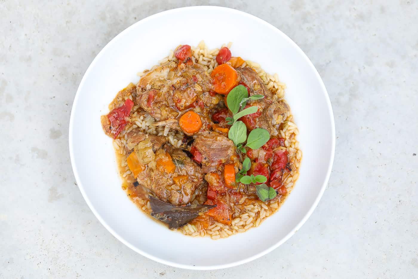 country-style pork ribs with rice topped with sauce and carrots