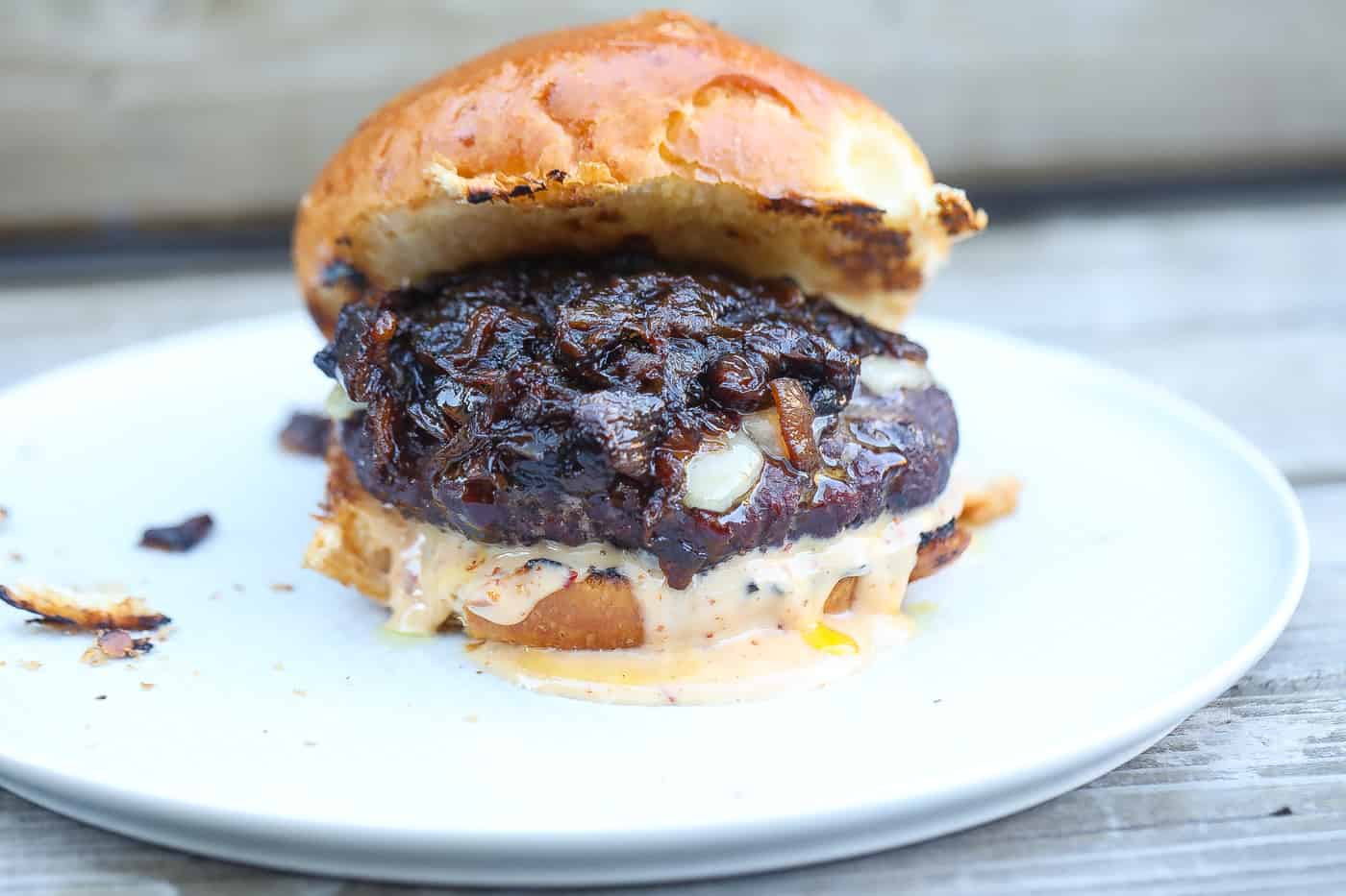 smoked burger with melted cheese, sauce, and caramelized onions