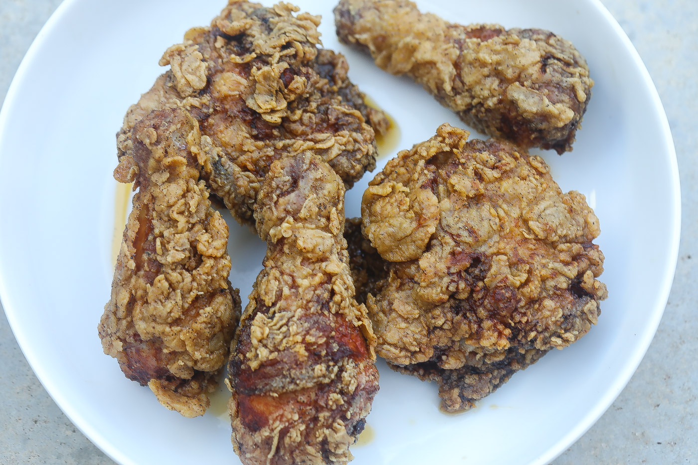 Southern fried chicken pieces on a white plate