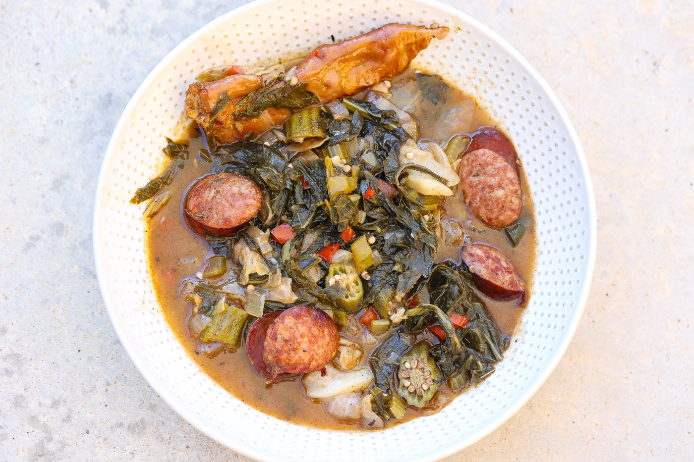 cooked gumbo z'herbes in a white bowl with spoon.