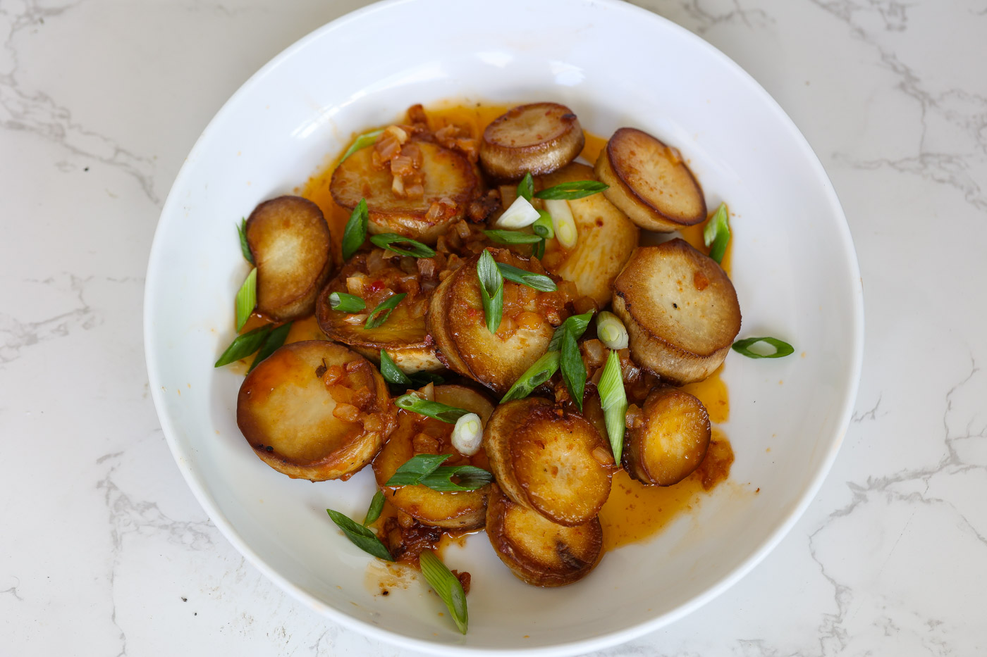 vegan mushroom scallops in white bowl topped with green onions