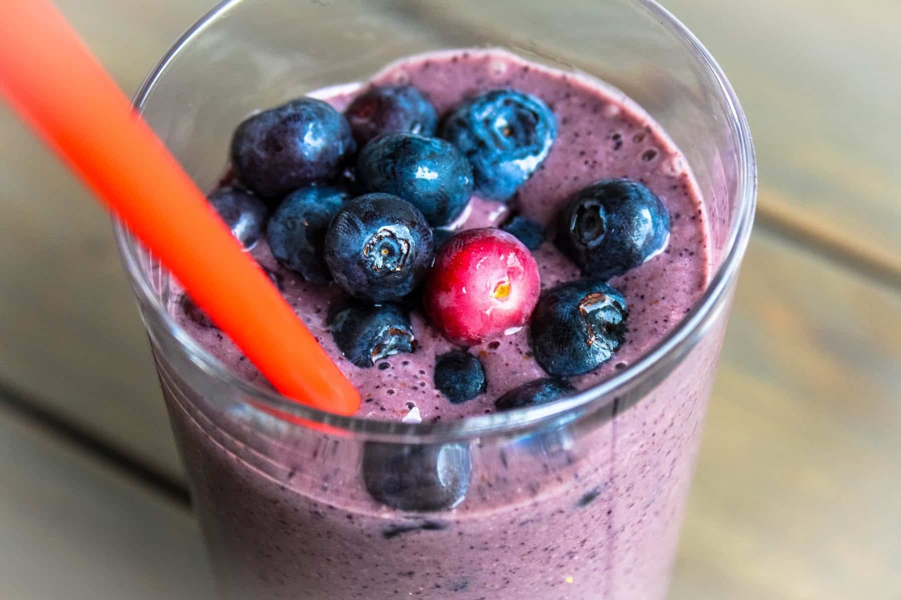 smoothie in a glass topped with blueberries