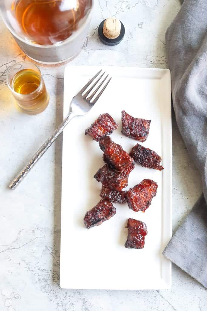 smoked pork belly burnt ends on a white plate