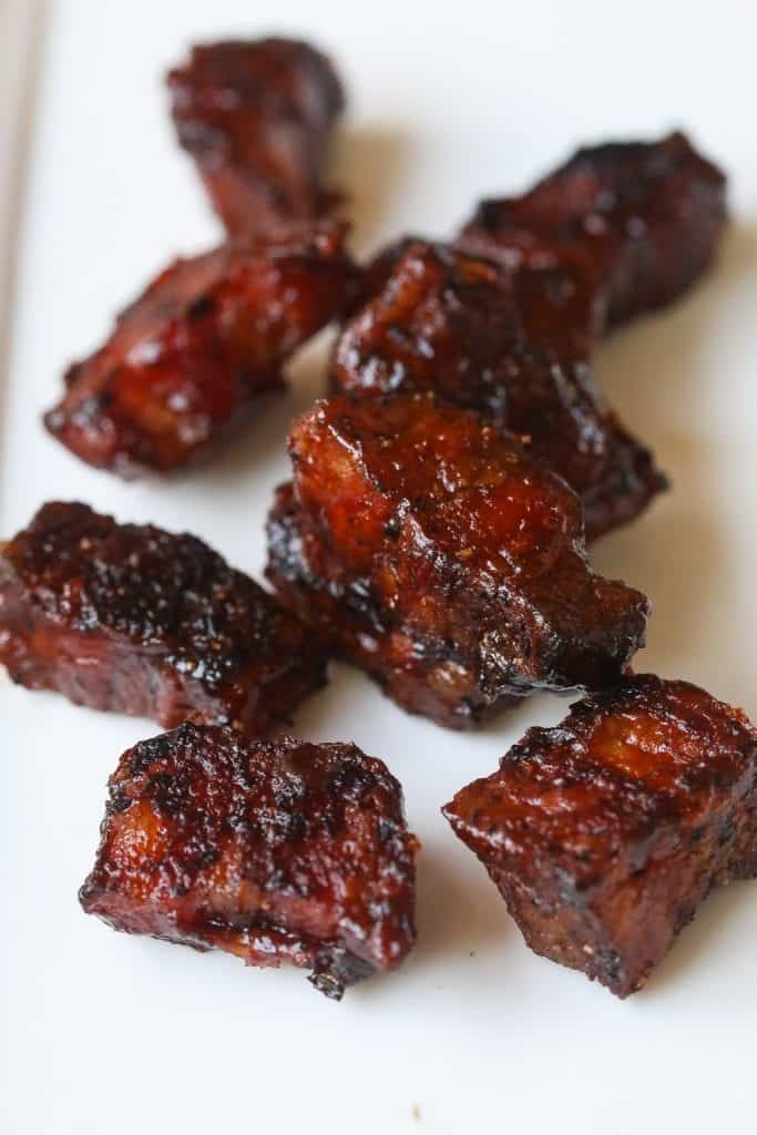 smoked pork belly burnt ends on a white plate