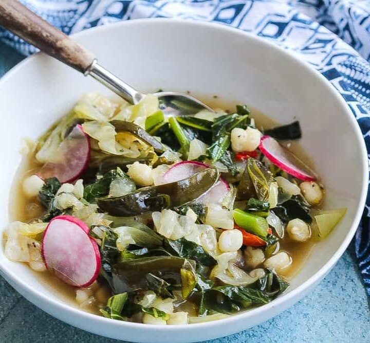 vegan cabbage poblano pozole with collard greens in a bowl