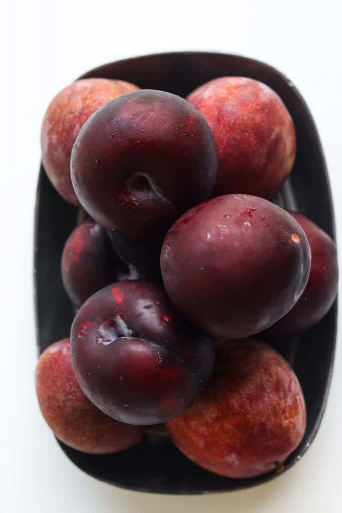 dark plums piled on a plate