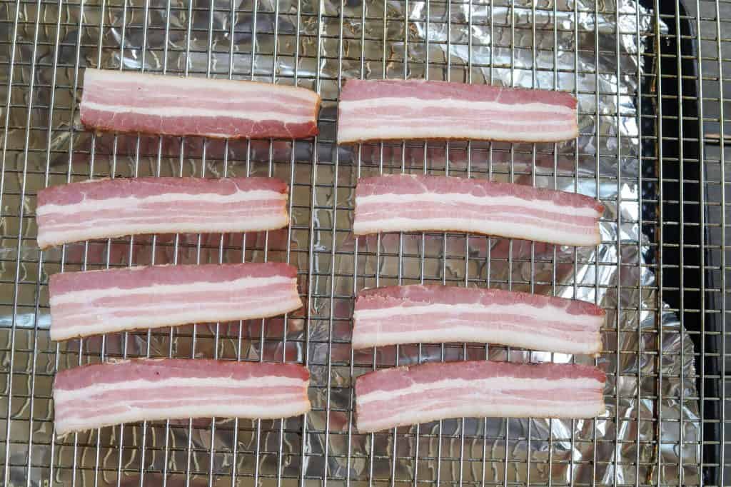 raw bacon on wire rack and tray
