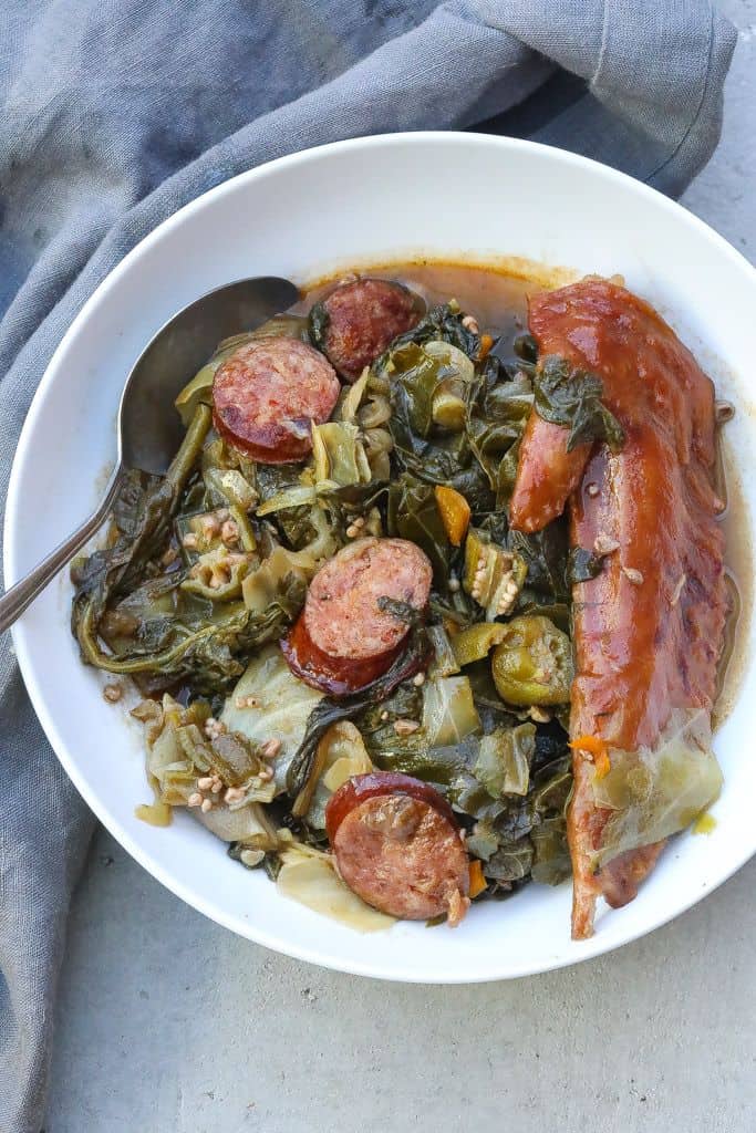 cooked gumbo z'herbes in a white bowl with spoon.