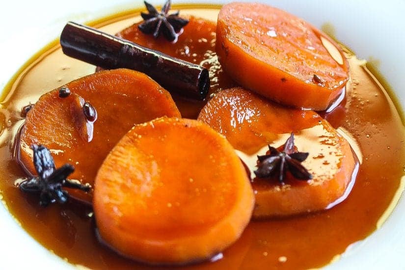 Mexican sweet potatoes(camote enmielado) in bowl topped with syrup #dessert #sweetpotatoes www.foodfidelity.com