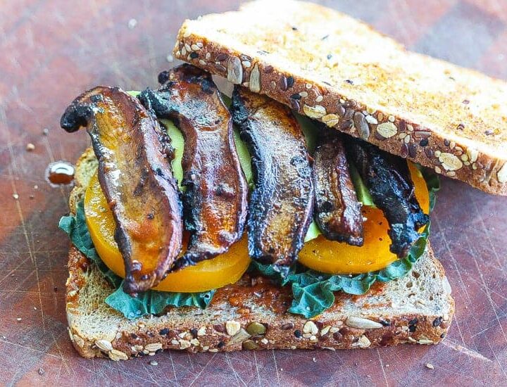 Vegan BLT Sandwich with mushroom slices with yellow tomatoes and black kale on two slices of bread