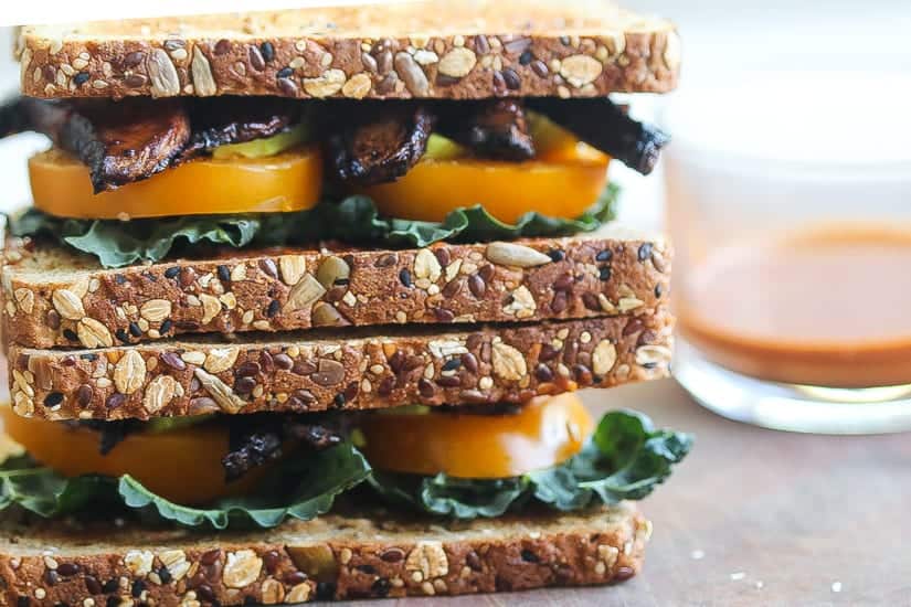 Vegan BLT Sandwich with mushroom slices with yellow tomatoes and black kale on two slices of bread