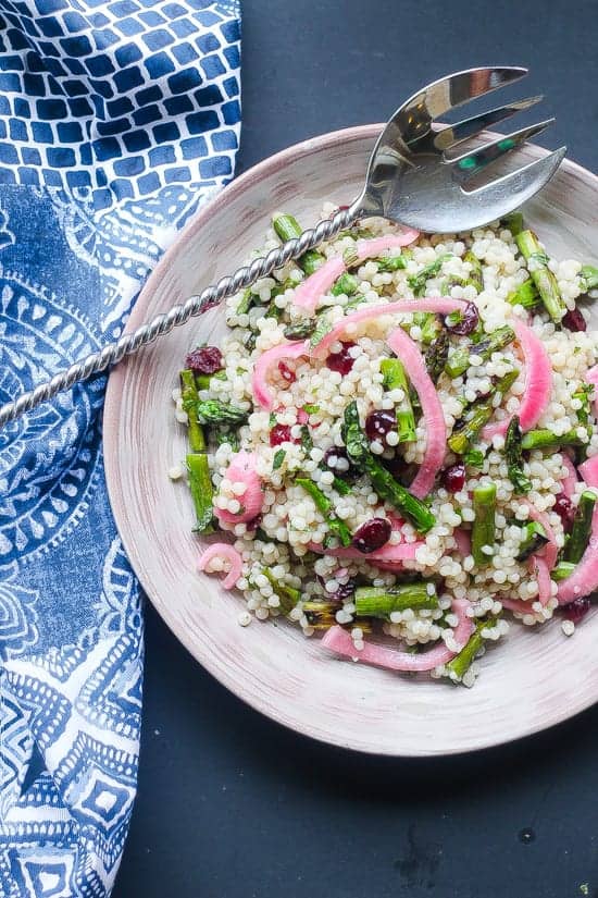 citrus israeli couscous with asparagus and cranberries on a plate