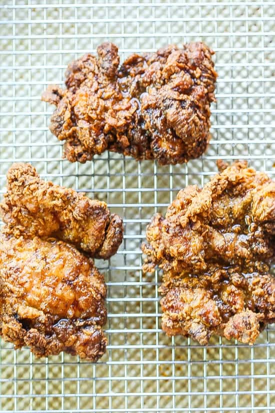 garam masala spiced fried chicken thighs on a wire rack