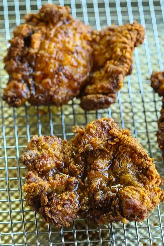 garam masala spiced fried chicken thighs on a wire rack