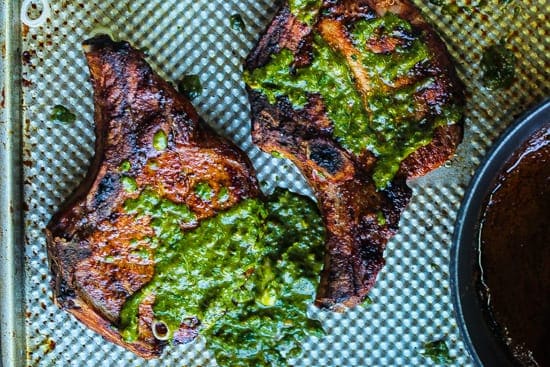 grilled puerto rican pork chops topped with chimichurri sauce