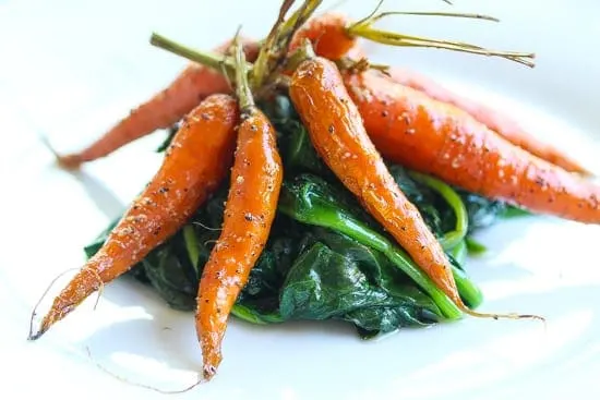 simple smoked carrots on a plate of spinach