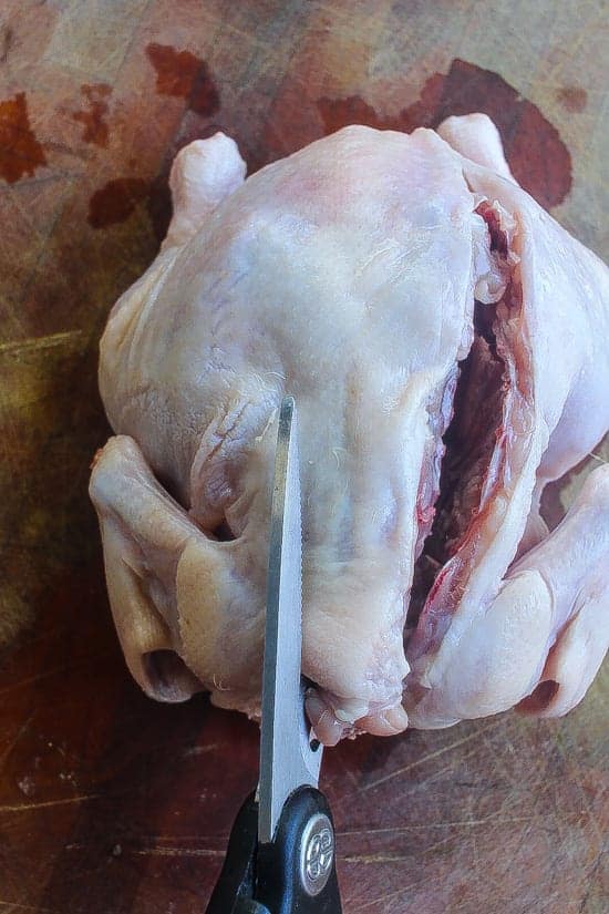 raw chicken being cut via butterfly technique