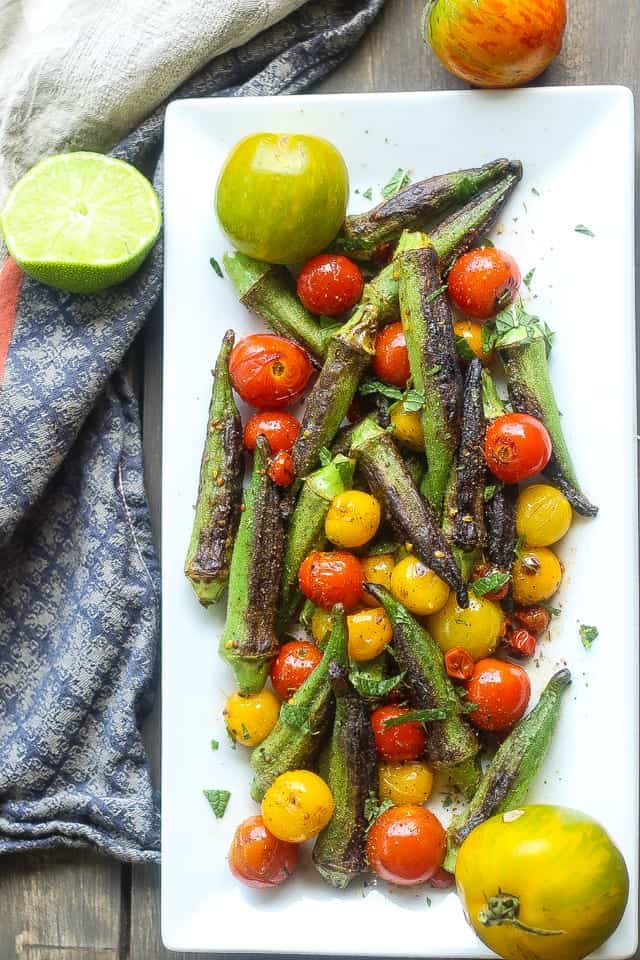 skillet blistered okra and tomatoes on a white platter