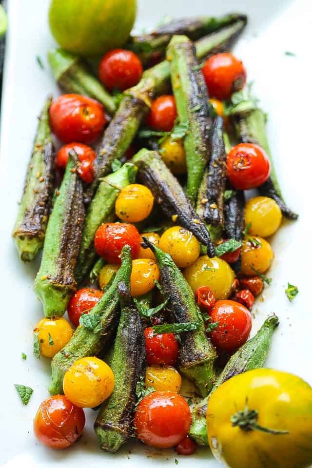 skillet blistered okra and tomatoes on a white platter