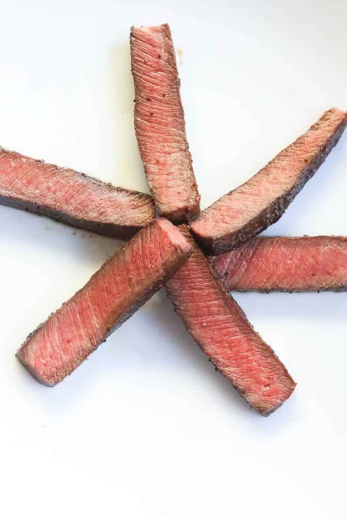 sliced flat iron steak on white plate