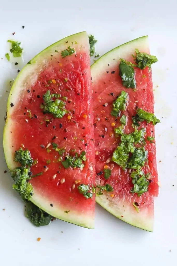 watermelon salad on a plate topped with mustard green chimichurri sauce