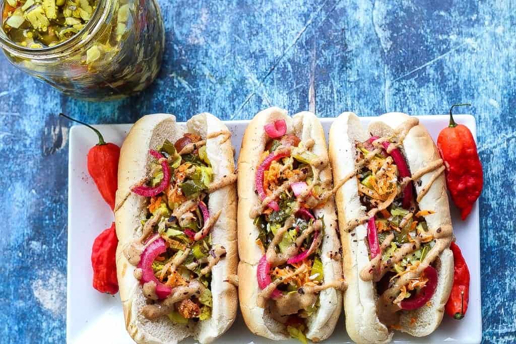 andouille sausage hot dog topped with mustard, pickled red onions, and chow chow