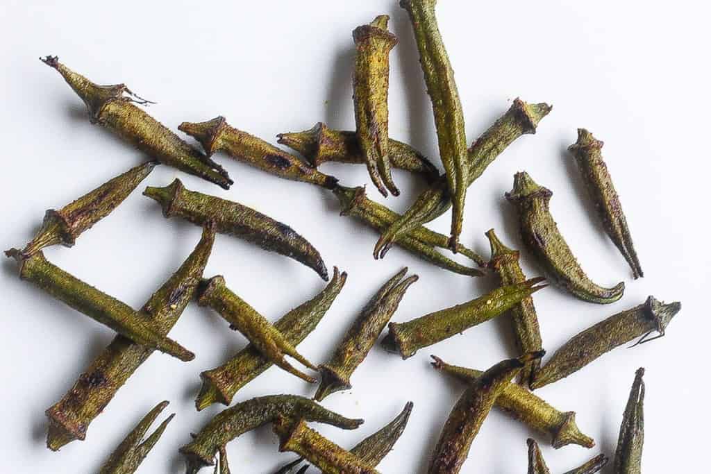 roasted okra pods on a white plate