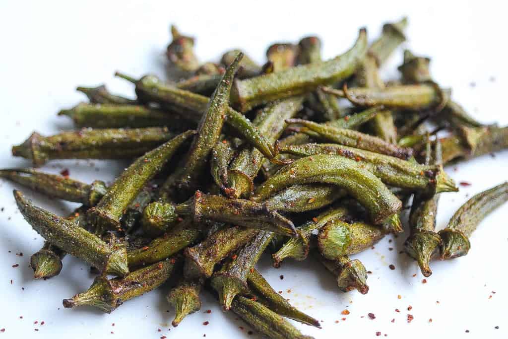 roasted okra pods on a white plate