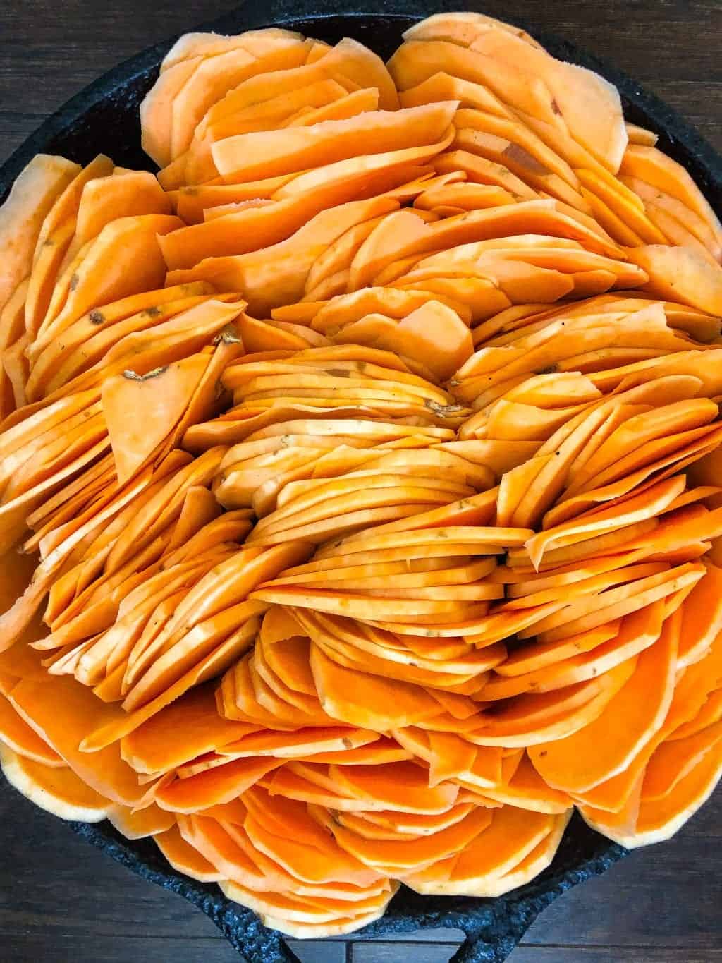 slices of raw sweet potatoes in a skillet