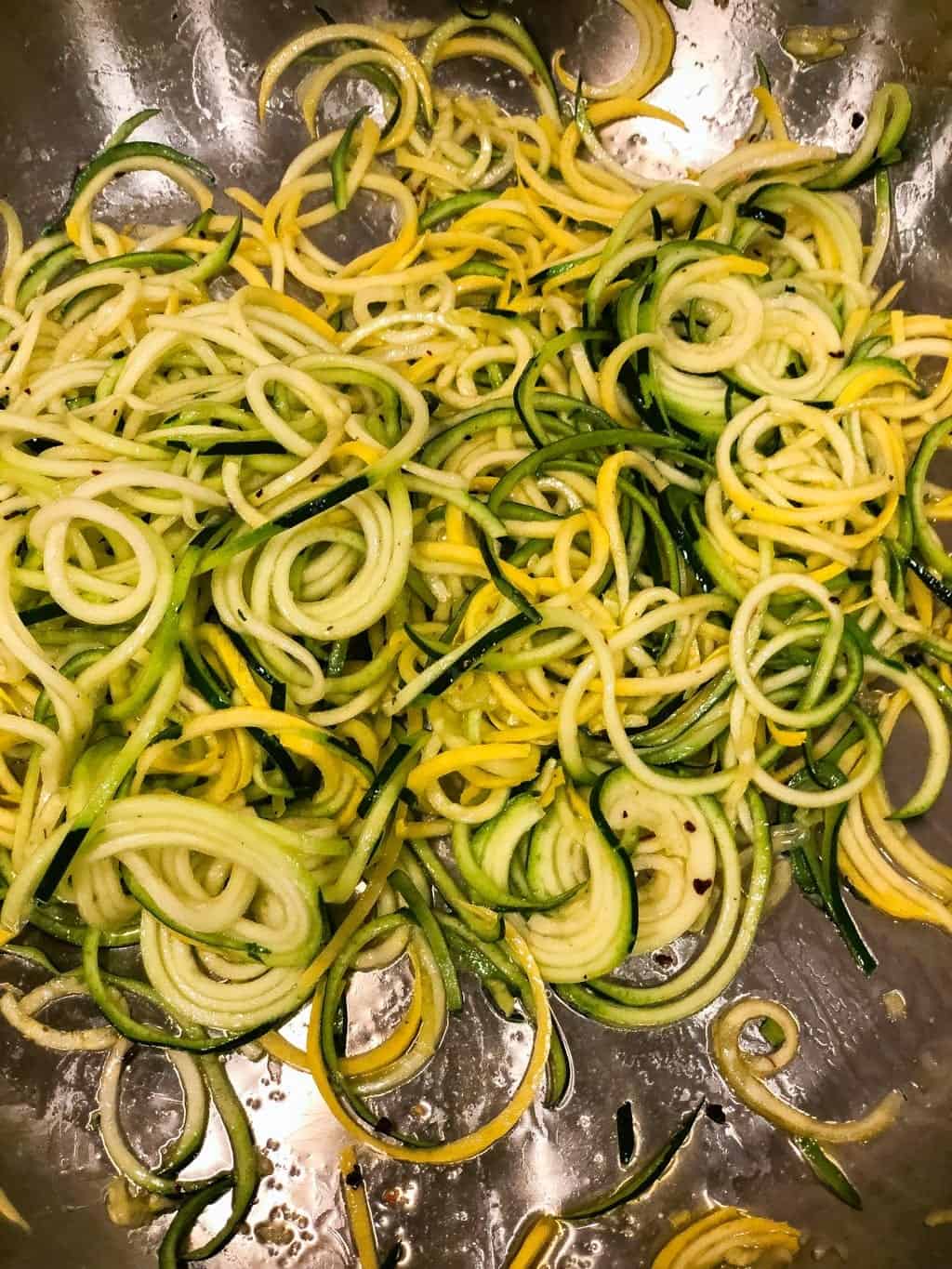 zucchini noodles cooking in pan