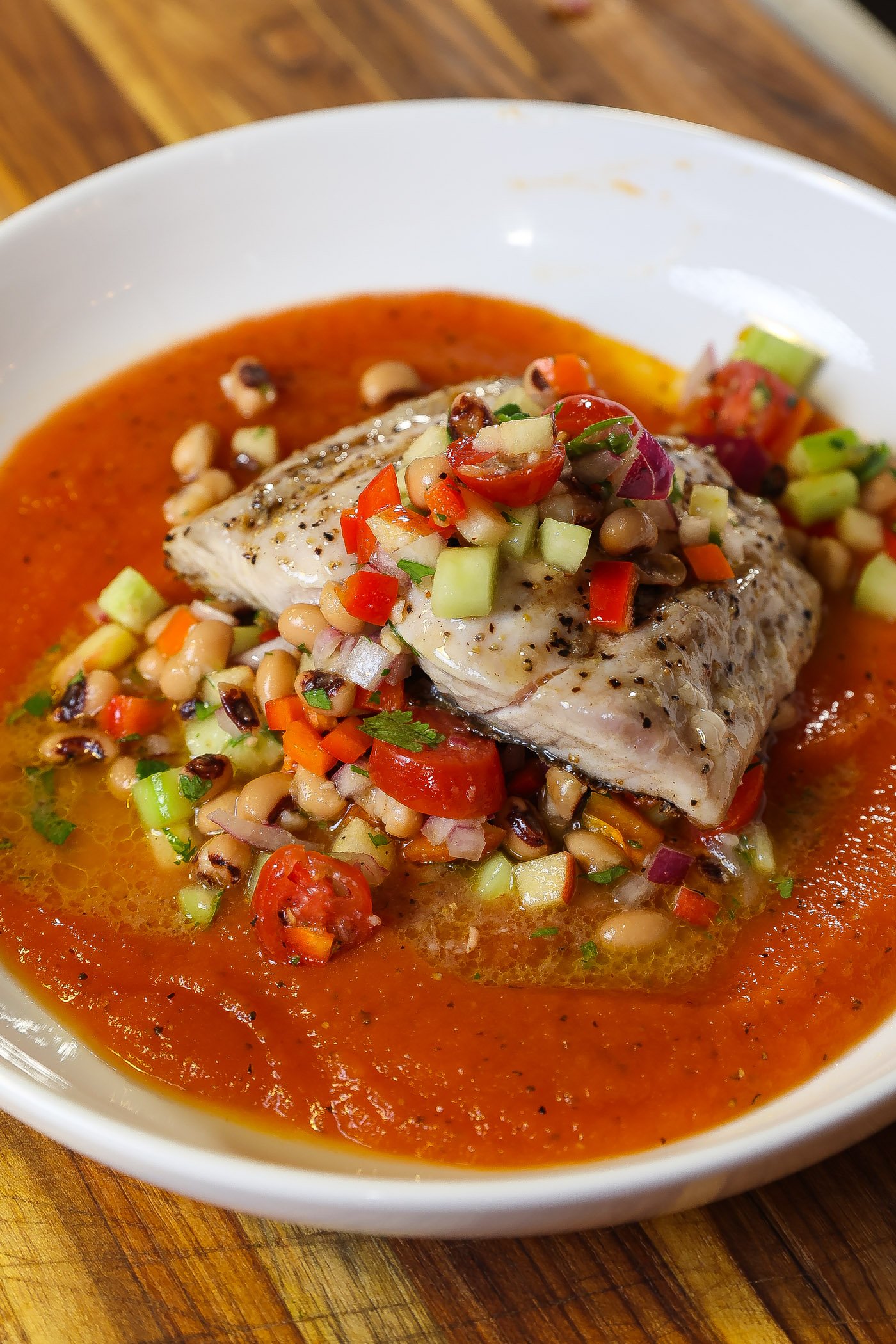 grilled mahi mahi on top of red papaya sauce and topped with blackeyed pea salad