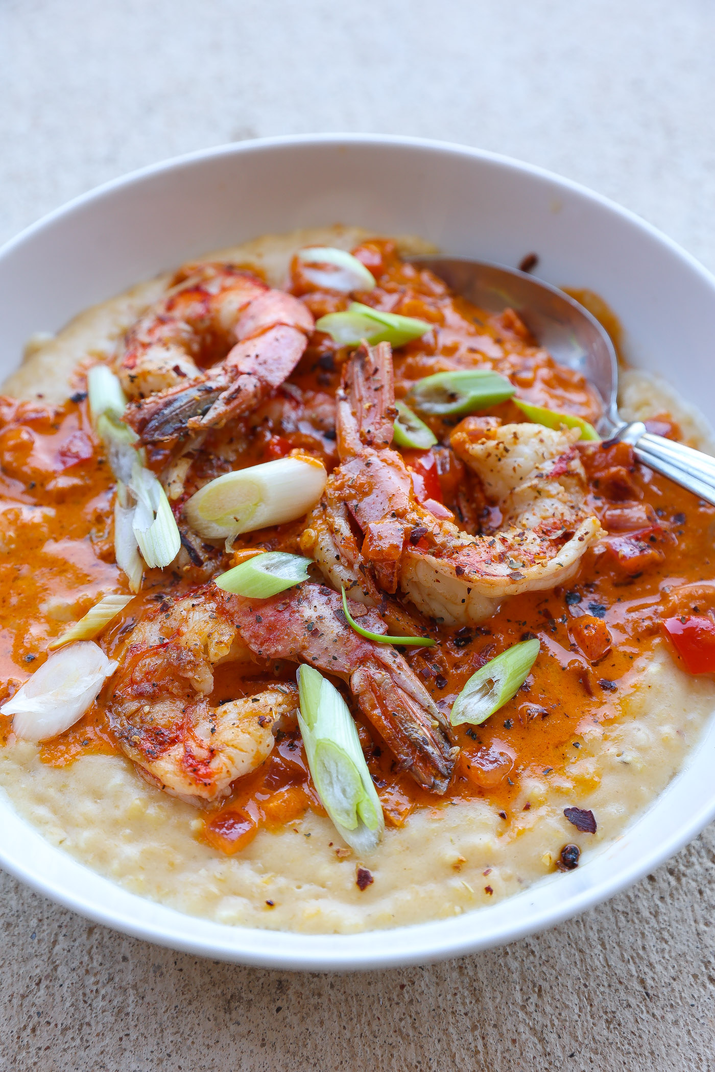 shrimp and grits in a bowl topped with red pepper sauce