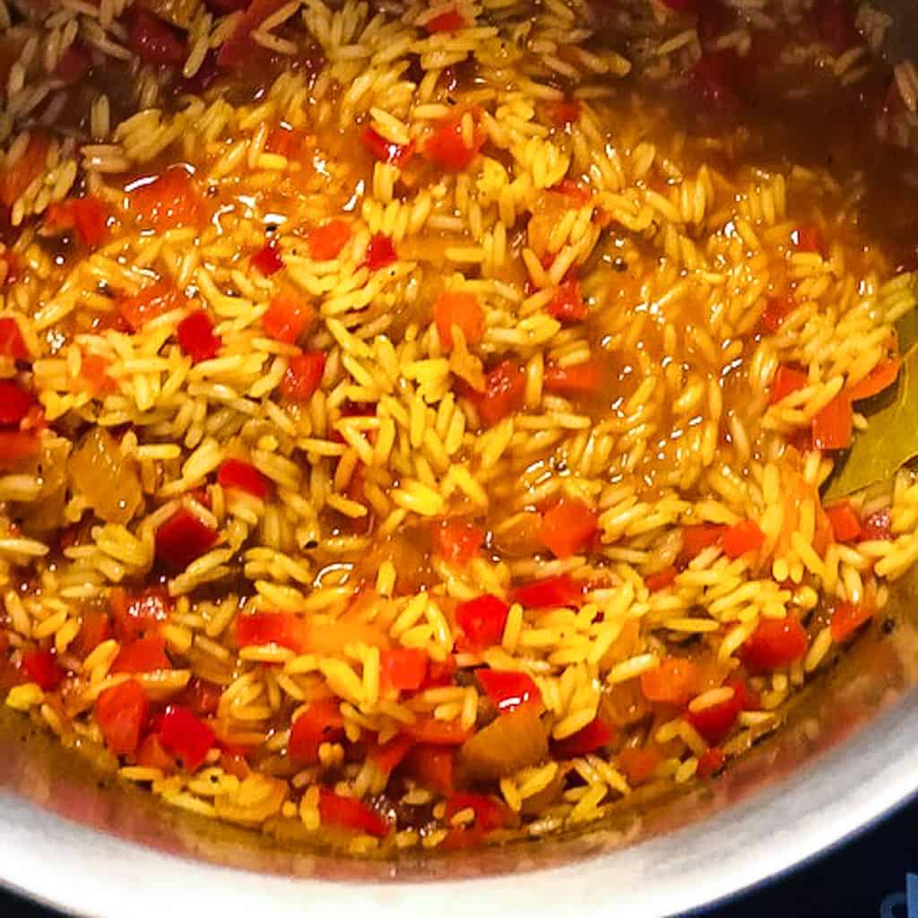 jollof rice with red bell peppers in pot